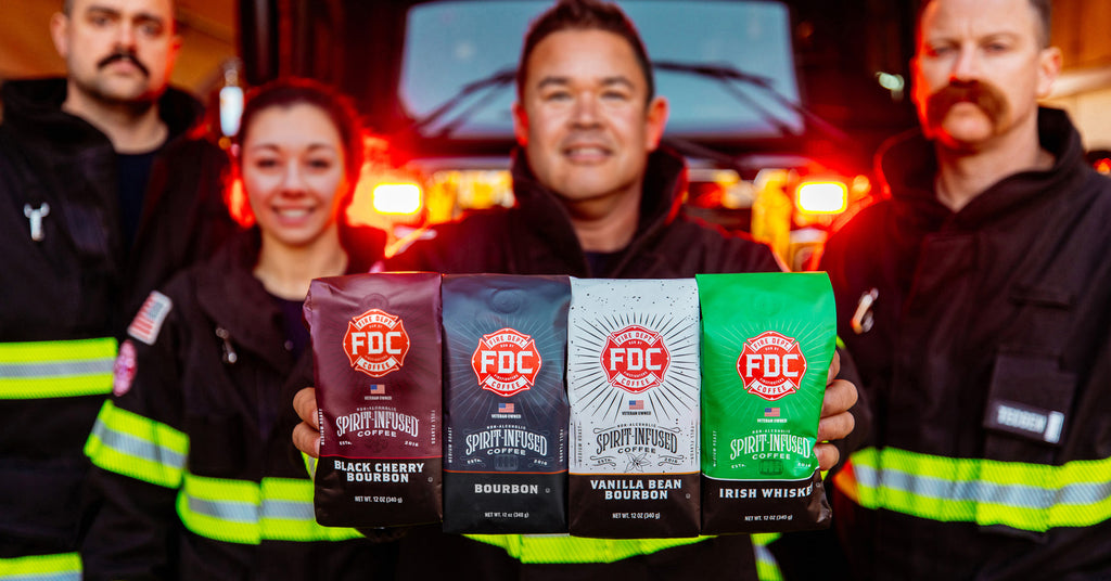 Firefighters gathered around a fire truck and holding four bags of spirit infused coffee.