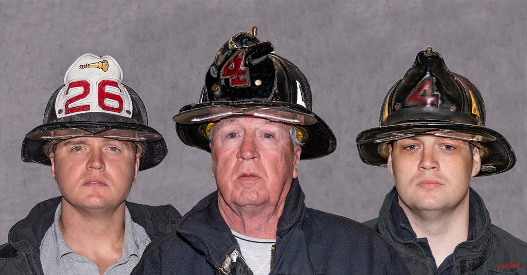 Three firefighters wearing bunker gear and helmet, looking at the camera.