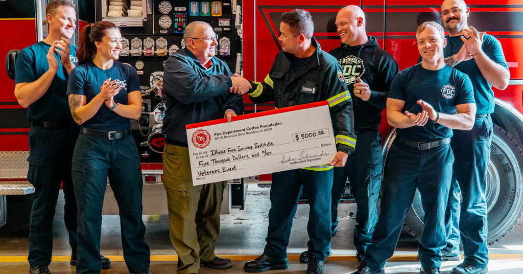 Fire Department Coffee handing an oversize donation check to help first responders.