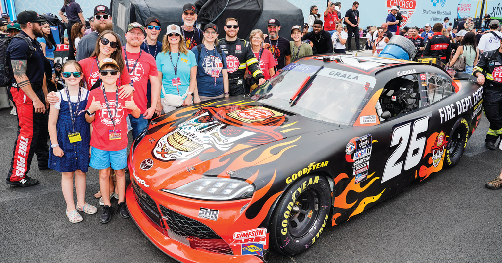 Team members and family members at FDC surrounding the Skull Crushing Espresso NASCAR car.