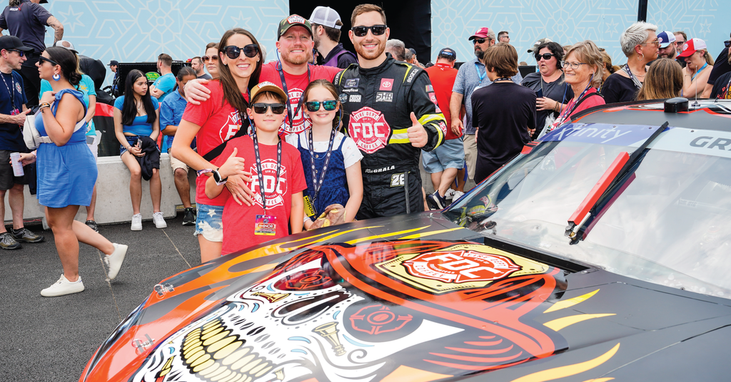 Fire Department Coffee founder and CEO, Luke Schneider, surrounded by family and Kaz Grala at the NASCAR Chicago street race.