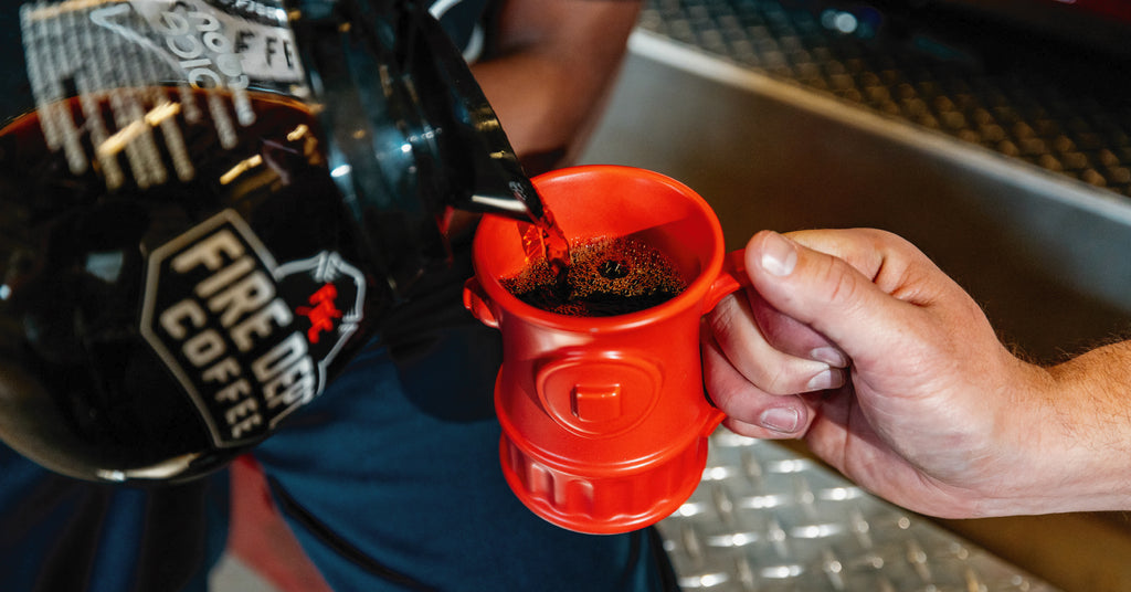 Coffee pot pouring coffee into a red fire hydrant mug.