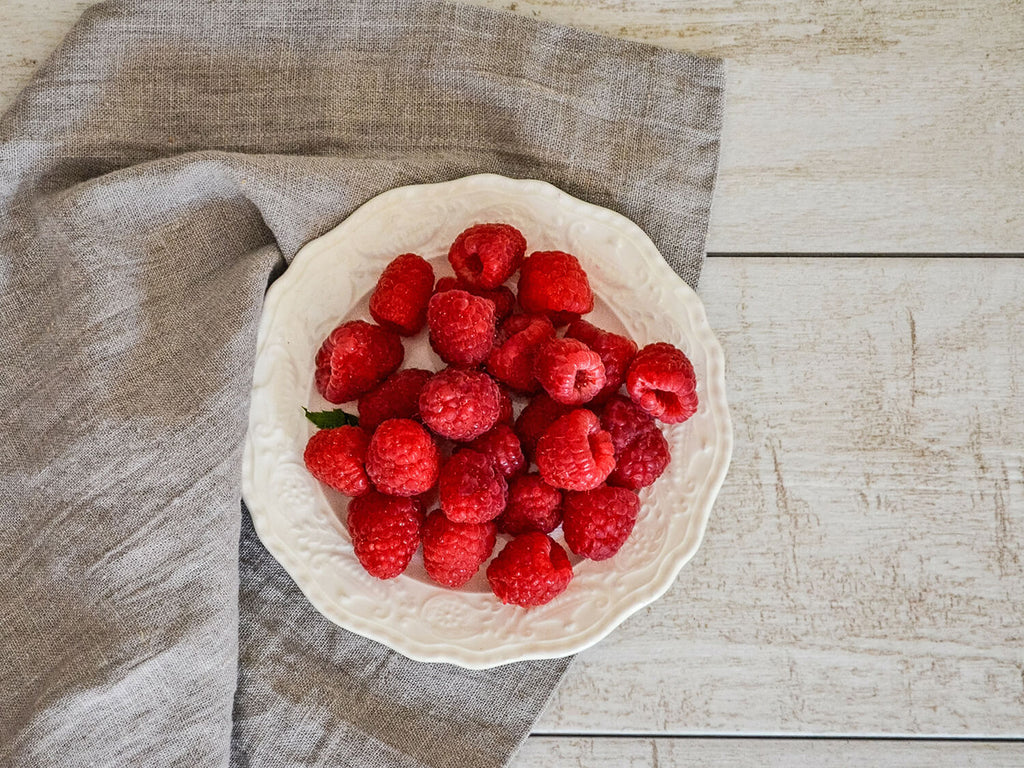 raspberries in a bowl with a linen napkin