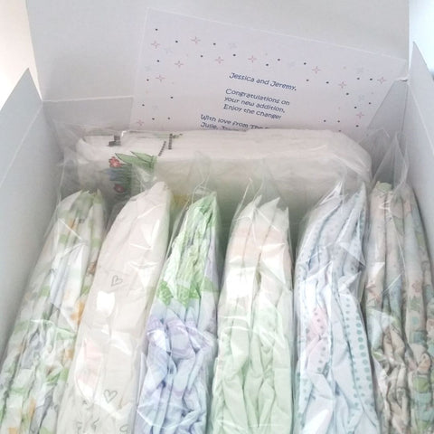 Photo of 7 Diaper Sample Packs in a white gift box with gift card partially readable "Jessica and Jeremy, Congratulations, enjoy the change!"