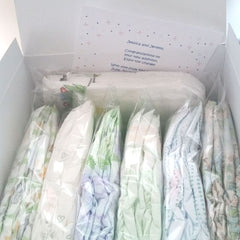 Photo of 7 Diaper Sample Packs in a white gift box with a gift card tucked in , partially visible reading "Jessica and Jeremy, Congratulations on your new addition, enjoy the change With Love from Julie" (rest of card is hidden from view)