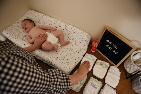 Baby with diapers, text on board "why try just one"