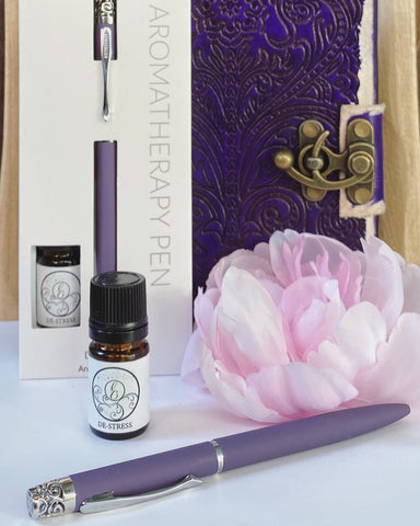 Photo of Essential Oil pen and bottle of essential oil with a lavender flower and in the background a gift boxed set of same pen with essential oil bottle