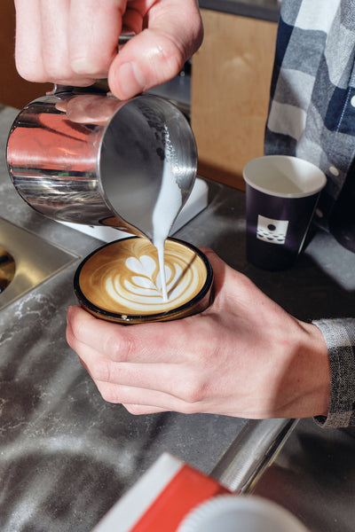 Barista pouring latte at Night Swim Coffee CLT