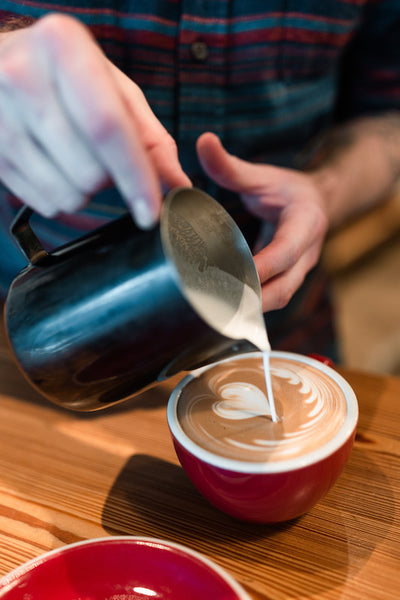 barista pouring latte art at Rare Bird D.C.