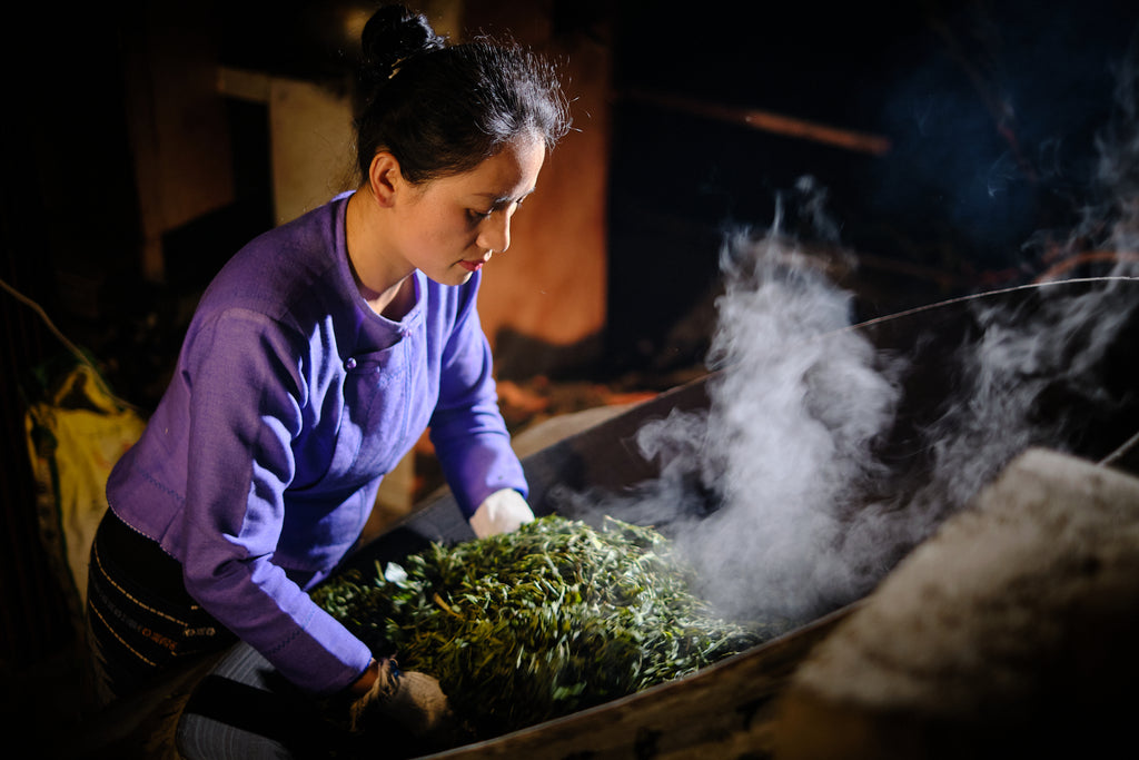 yubai cooking tea leaves in a large wok