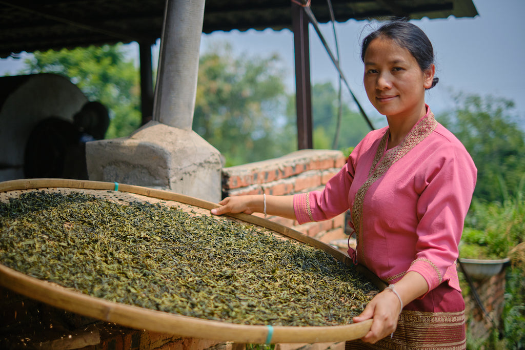 yubai holding a bamboo basket filled with tea leaves