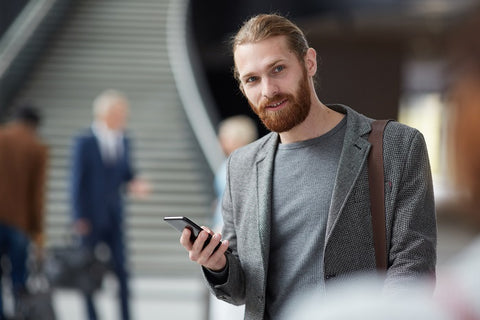 man with beard holding a phone