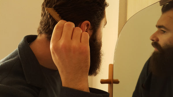 Bearded man combing his hair