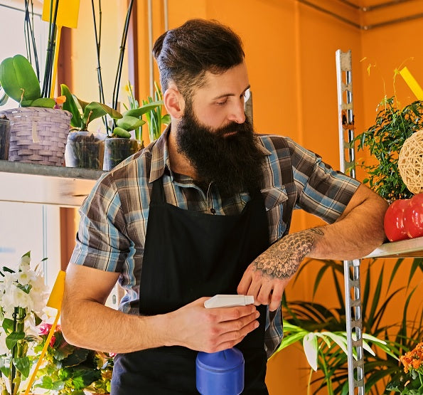 man with big beard watering the plants