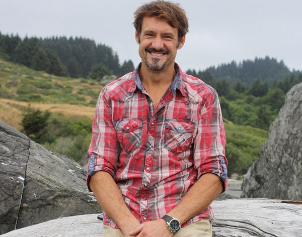 a man with a van dyke beard sitting in a rock