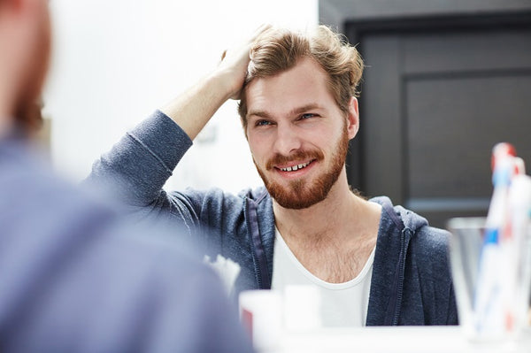 man styling his hair with hair powder