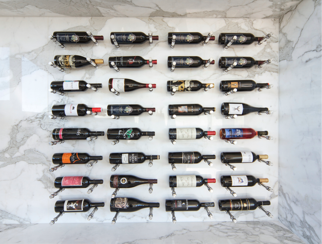 Wine peg wine storage system on a marble wall.