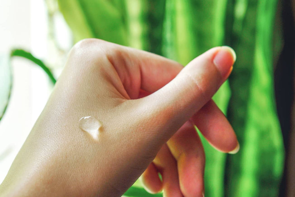 A drop of fresh harvested aloe vera on a woman's hand