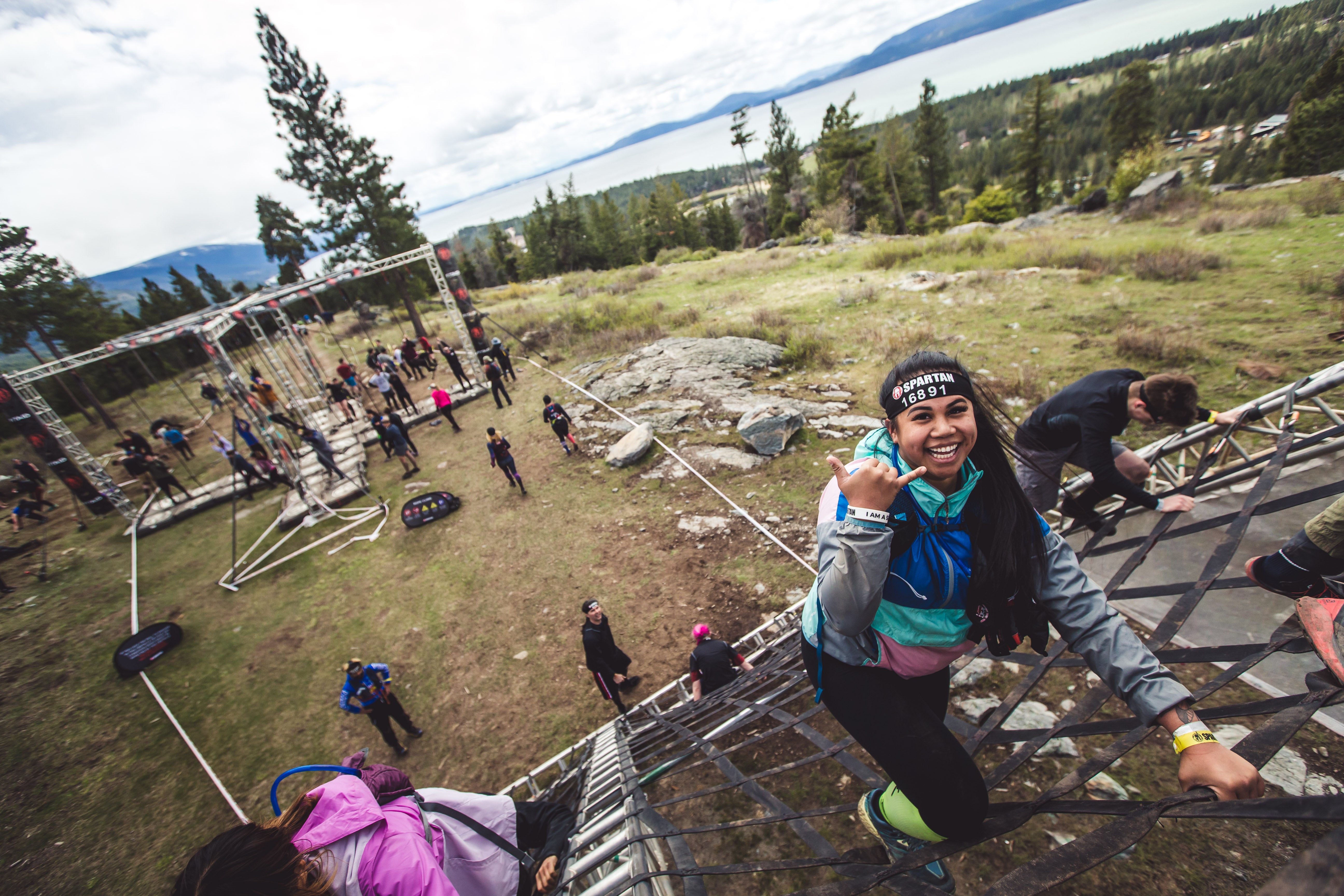 a spartan racer climbing an obstacle in montana