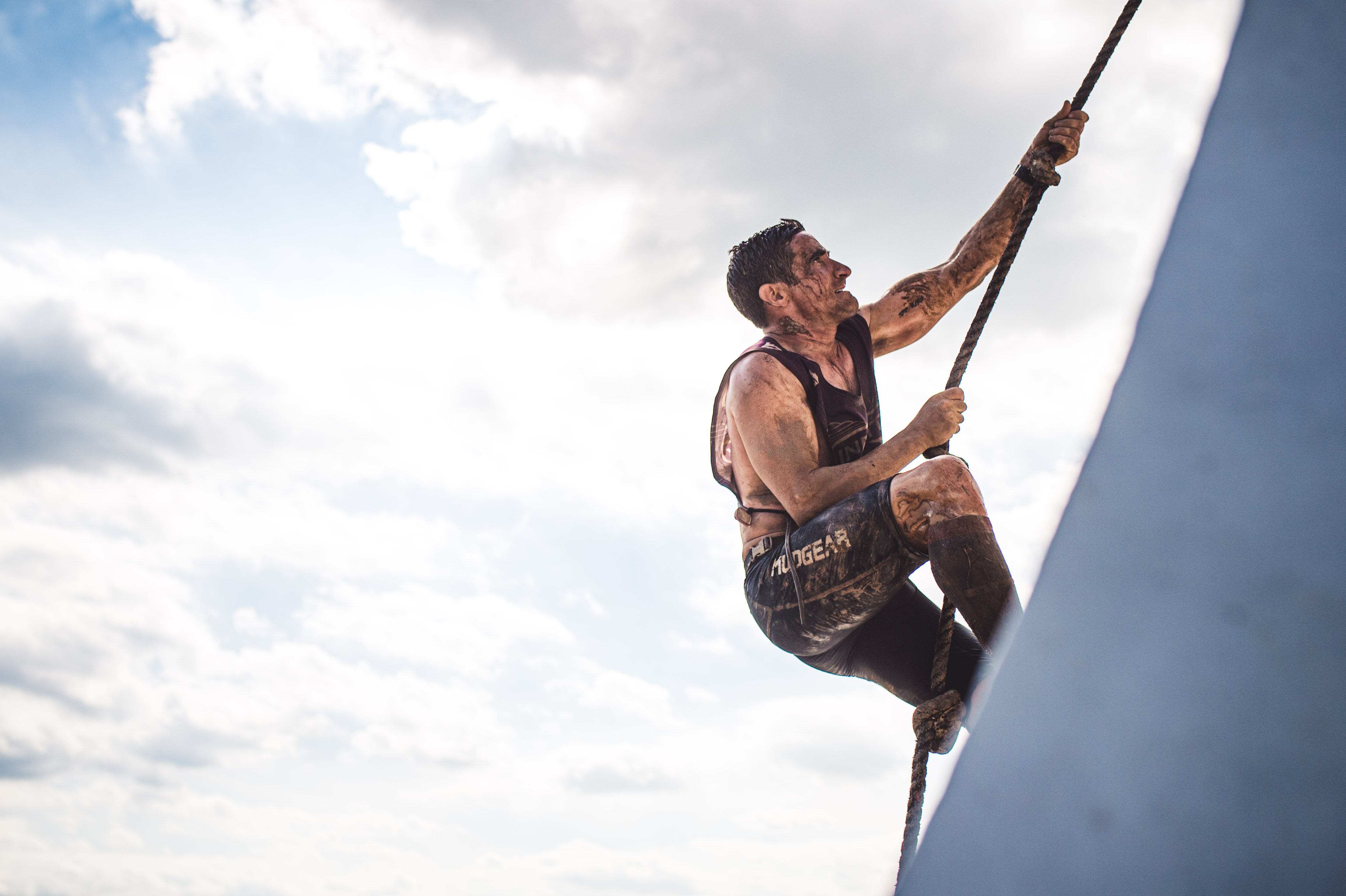 a tough mudder racer climbing an obstacle