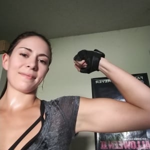 Misty Williams flexing her arm after achieving her goal of 2500 burpees