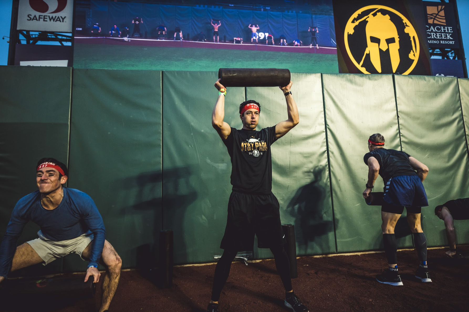 a spartan racer completing the weighted ram burpee obstacle at a stadion race