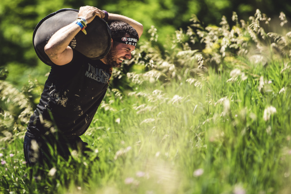 a spartan racer carrying a sand bag