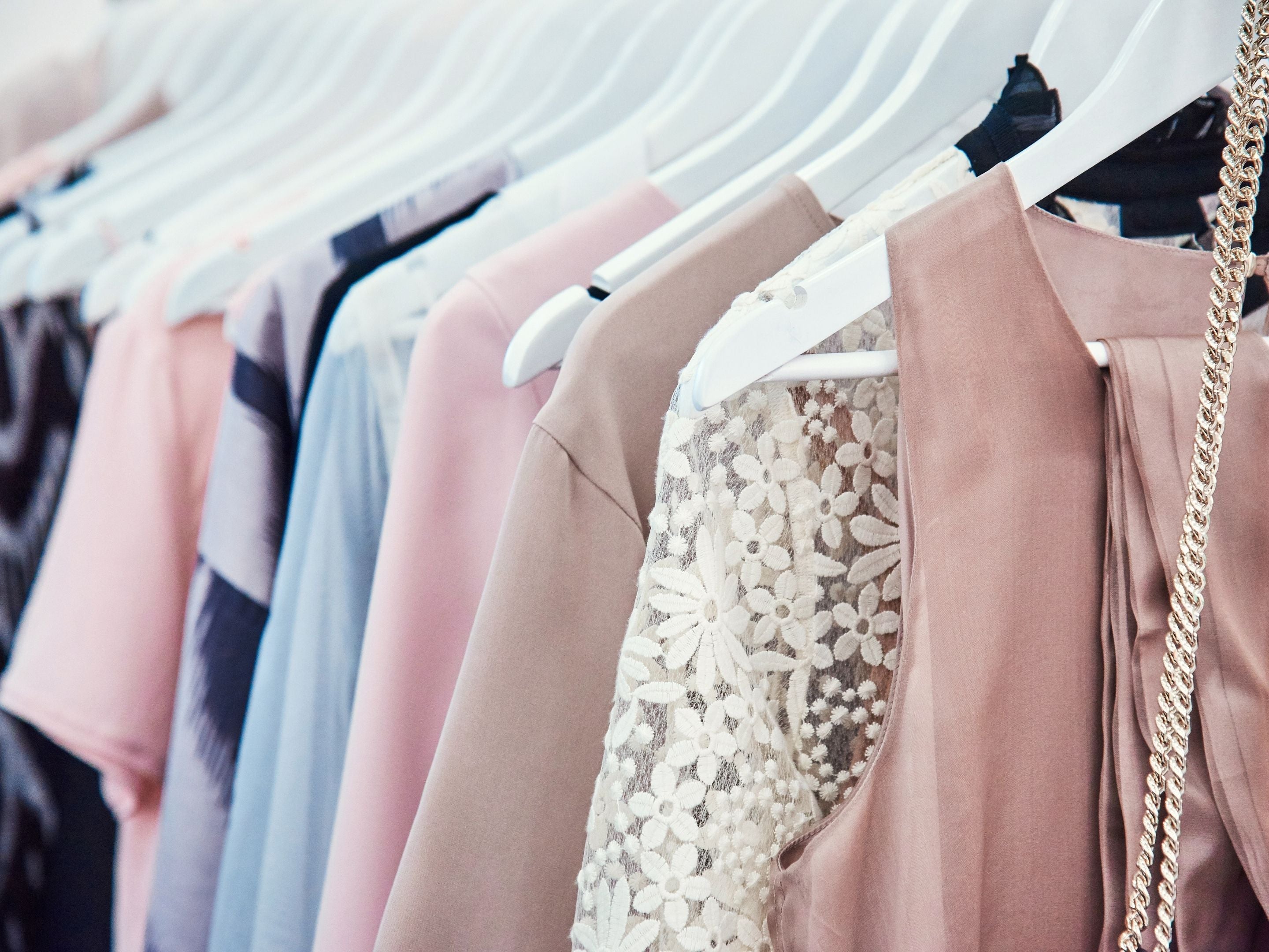 Assorted Garments Hanging in a Closet on Hangers