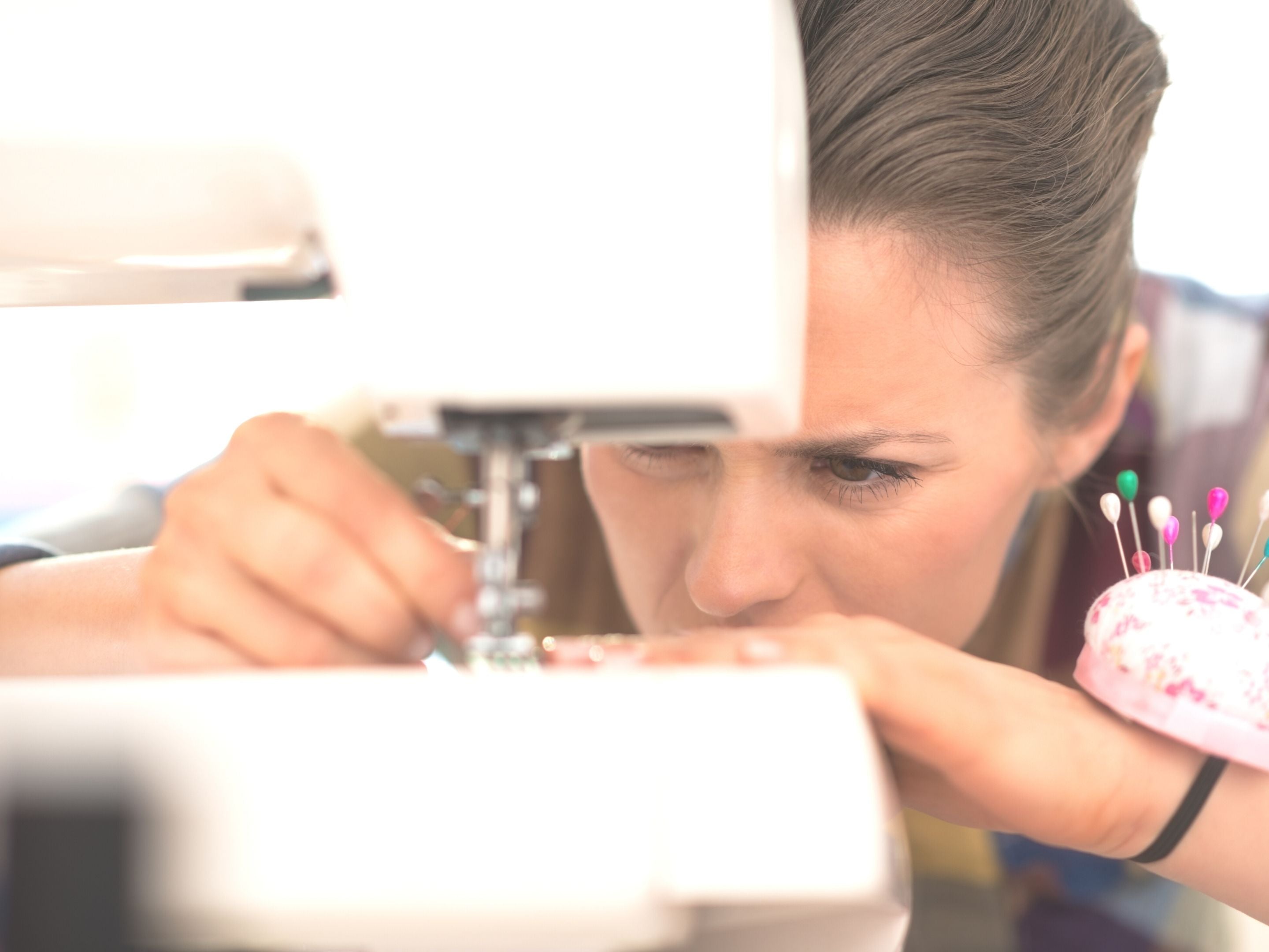 Sewist Closely Examining Sewing Machine