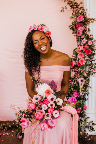 Model with pink bouquet with pink silk ribbon by The Lesser Bear and floral arch. Photo by Adrienne Gerber and florals by Rachel Forrer