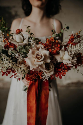 Bride holding bouquet with red silk ribbon photo by Grace E Jones Florals by Bear Roots