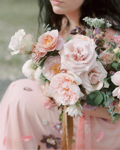 Model wearing a pink dress and holding a bouquet of flowers by Passiflora Studios. Styling by Auburn and Ivory Creative Photo by Jenny Haas and Silk Ribbon by The Lesser Bear