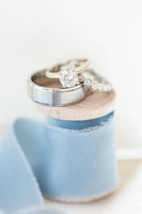 Wedding rings on a spool of blue ribbon by The Lesser Bear Photo by Hope Taylor Photography