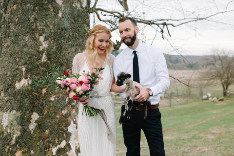 Bride and Groom Holding a Lamb and Bouquet with Naturally Dyed Silk Ribbon by The Lesser Bear Photo Tiernae Salley Florals Old Slate Farm
