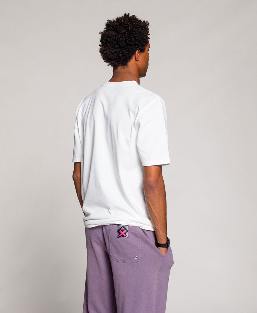 Man facing backwards wearing a white shirt with purple pants