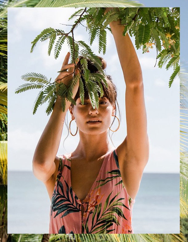 Woman-wearing-a-pink-dress-holding-a-plant-with-both-hands