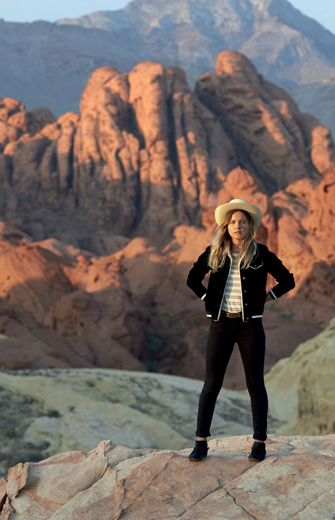 Woman wearing black jacket with white top and black pants white hat black shoes