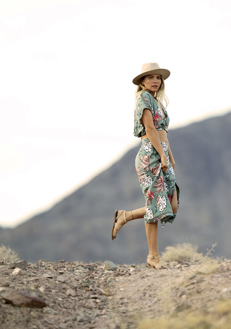 Woman wearing floral top and skirt with white fedora