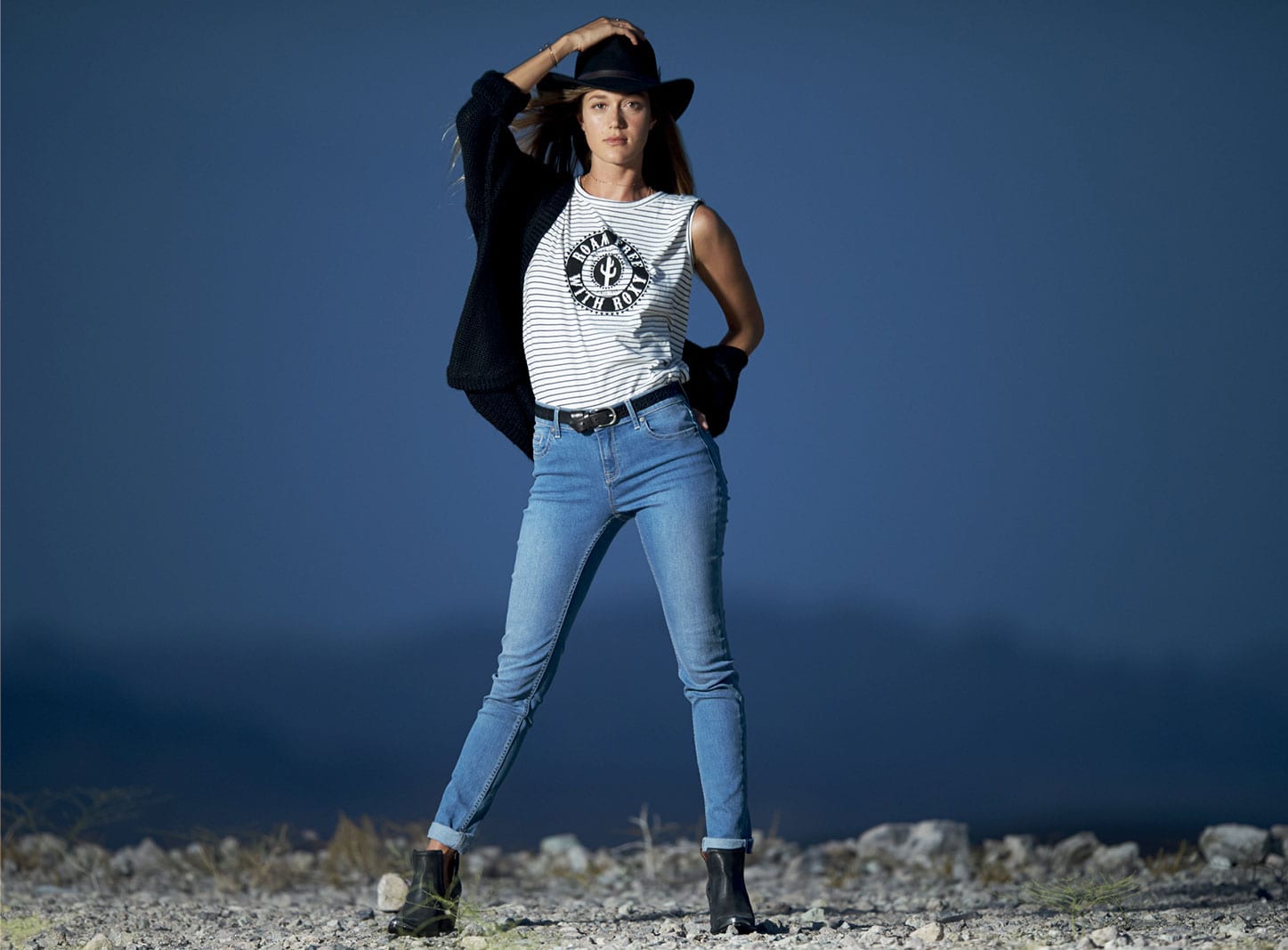 Woman wearing white sando shirt and jeans with black hat and black shoes