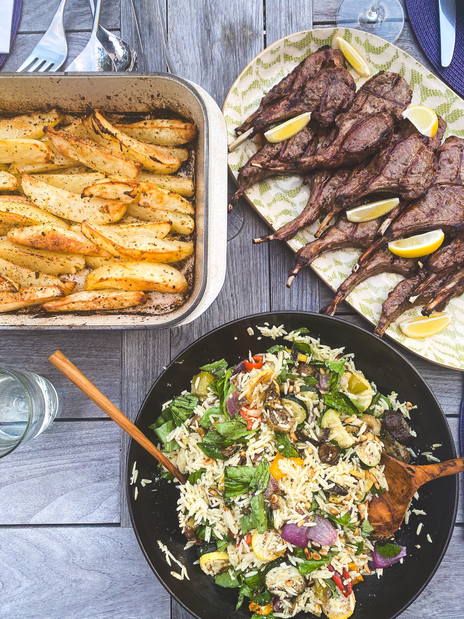 dinner menu of greek potatoes, orzo, and lamb chops