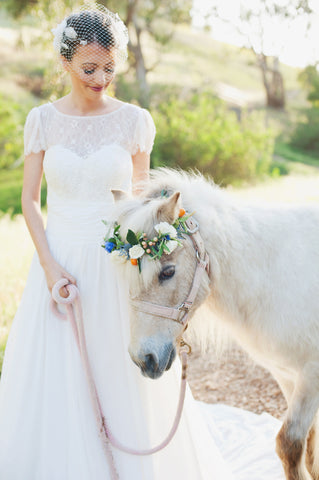 Bride in wedding dress with white pony