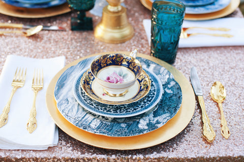 Champagne sequin tablescape with gold and blue table setting.