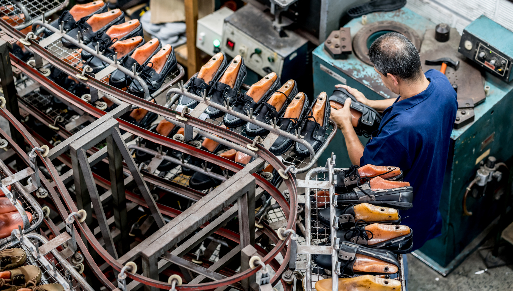 Latin American man making shoes at a factory in the production line