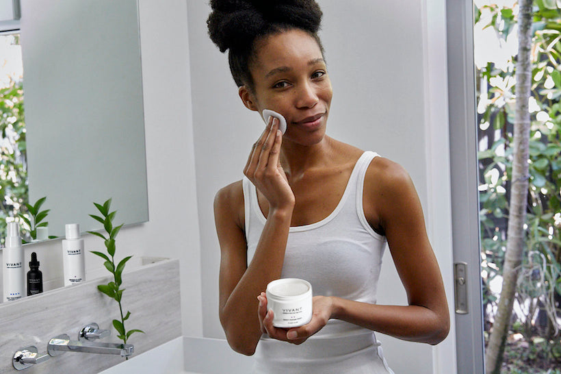 African American model holden Vivant's Daily Repair Pads in modern bathroom