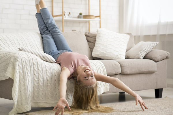 Woman laughing and laying on a couch upside down