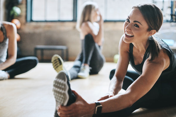 Women sitting on the floor stretching and doing yoga