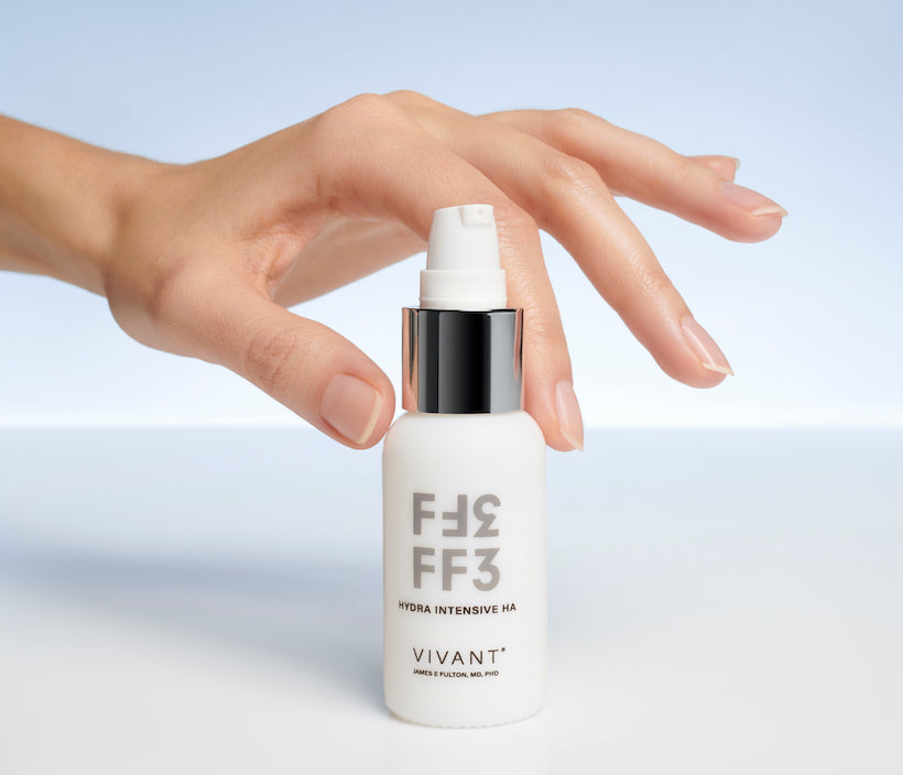 hand grabbing a serum white bottle with gray letters