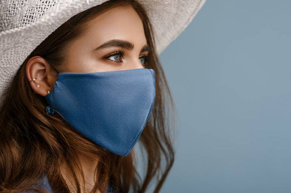 Woman wearing a blue face mask and looking to the side