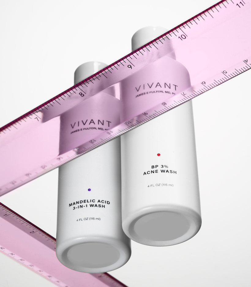 shot from below of two white cleanser bottles and pink rulers