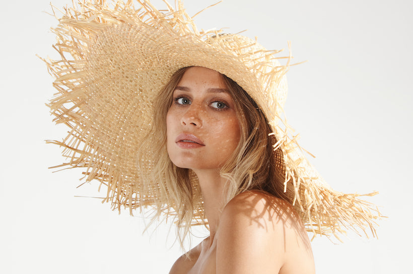 Portrait of beautiful fashionable woman wearing straw summer hat